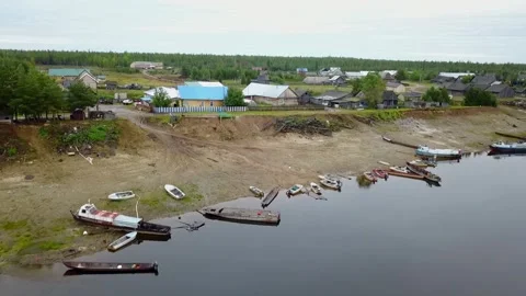 Flying a copter over a river and a village. Stock Footage 255069322
