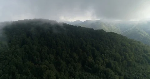 Flying copter through clouds over the beautiful sunny mountains covered with Stock Footage 85898884