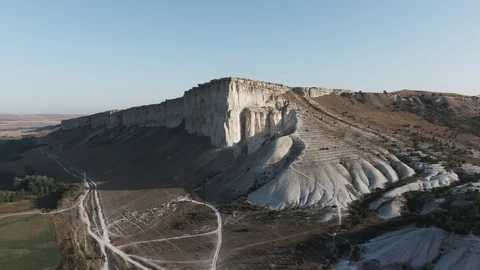 Flying at dawn to a white rock Several tourists gathered at the top to meet the Stock Footage 119859823