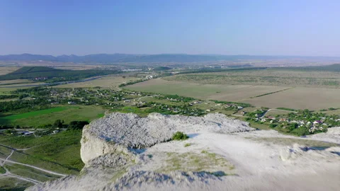 Flying directly over the white cliff and overlooking the valley with fields and Stock Footage 152337953