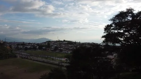 Flying with a dji mini 2 drone through a sports field until arriving at a town Stock Footage 235932945