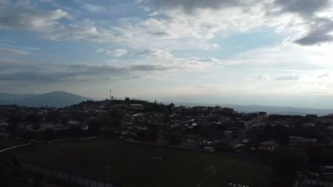 Flying with a dji mini 2 drone through a sports field until arriving at a town Stock Footage 235939347