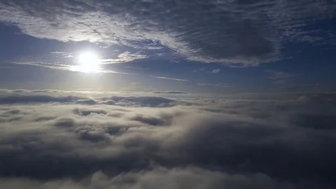 Flying down above the clouds during sunrise. Stock Footage 80016189
