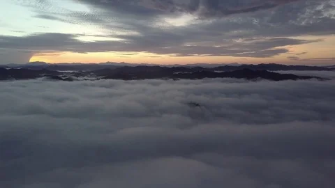 Flying down into the clouds during sunrise. Stock Footage 80006344