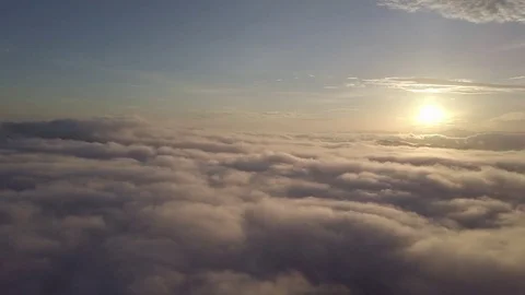 Flying down into the clouds during sunrise. Stock Footage 80018535