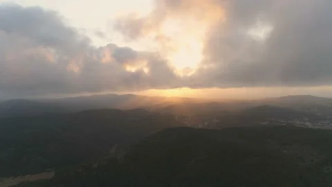 Flying down to the dark mountain forest. View of clouds and golden hour sunset Video stock 108106627