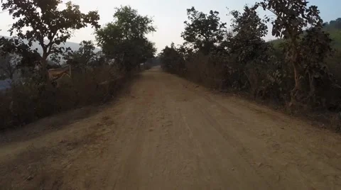 Flying down a Indian dirt road Stock Footage 65788085