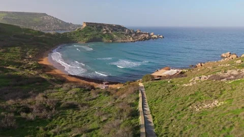 Flying down to Riviera Beach at Għajn Tuffieħa, Malta with views of the bay Stock Footage 330833059