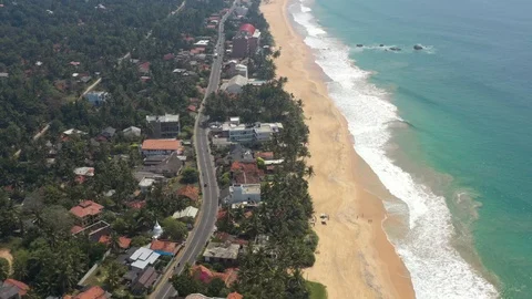 Flying on a drone above the beach and the ocean with waves at dawn. Sunny weathe Stock Footage 104856091