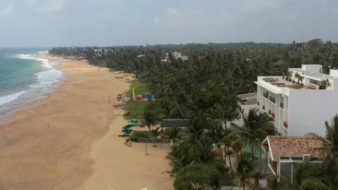 Flying on a drone above the beach and the ocean with waves at dawn. Sunny weathe Stock Footage 104856200