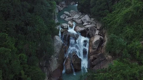 Flying on the drone above the wild waterfall in tropical palm forest. Beautiful 動画素材 112655788