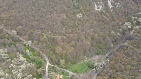 Flying a drone along the gorge along the cave city Stock Footage 253997264