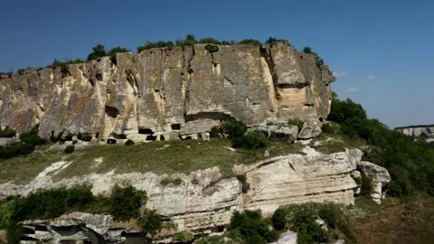 Flying a drone along a mountain with a cave city inside Stock Footage 160855245