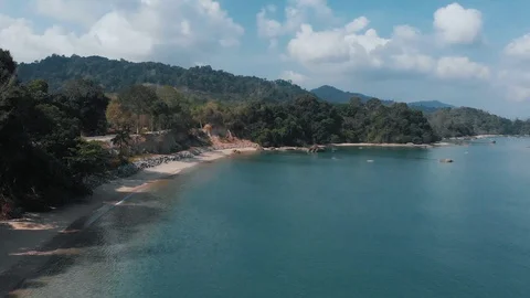 Flying drone along a sandy beach with a high cliff. Langkawi, Malaysia Stock Footage 106806548