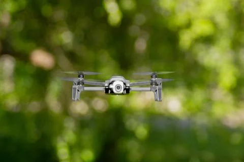 Flying drone with camera in the park Stock Photos