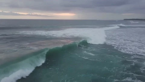 Flying drone captures the waves of the turquoise sea at sunset. Stock Footage 155972619