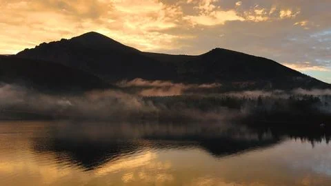 Flying a drone in the clouds over the Multinsky mountain lake in Altai Stock Photos