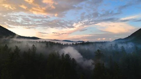 Flying a drone in the clouds over the Multinsky mountain lake in Altai Stock Photos