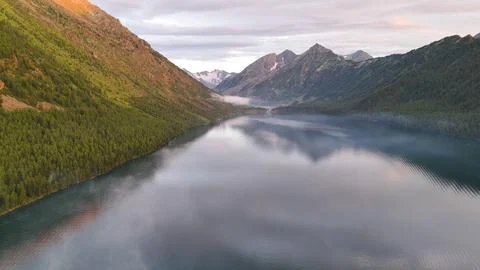 Flying a drone in the clouds over the Multinsky mountain lake in Altai Stock Photos