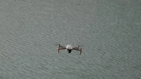 Flying drone, drone approaching camera while flying over lake Stock Footage 166366812