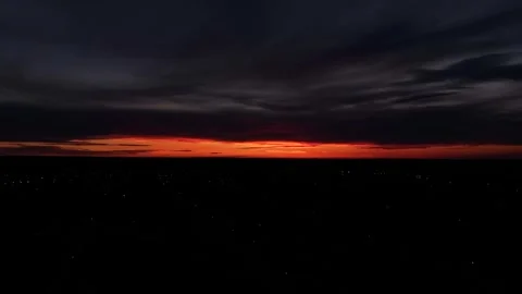 Flying a drone during a beautiful orange sunset with purples and blacks over lig Stock-Footage 312246675