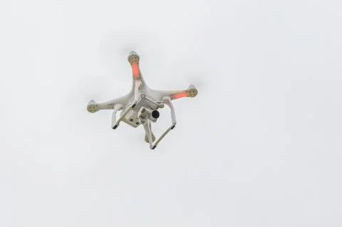 Flying drone on empty gray sky with camera Фото