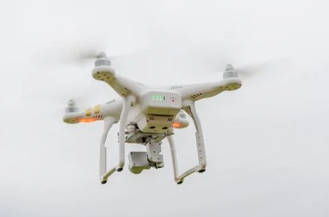 Flying drone on empty gray sky with camera from back 스톡 사진