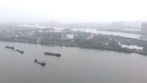 Flying drone, in the frame of poor visibility due to smog. Cargo barges float Stock Footage 118040878