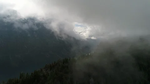 Flying drone to the lake through a cloud over a mountain with cedars Stock Footage 108029891