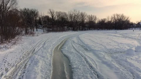 Flying with a drone at a low angle following the tire tracks in the snow Stock-Footage 164344240