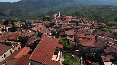 Flying a drone low over an ancient small town in the mountains of the Italy Stock Footage 272752431