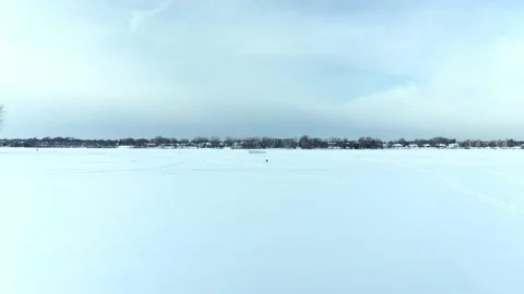 Flying with a drone mid-air towards the fort made of snow on the frozen river 動画素材 164344387