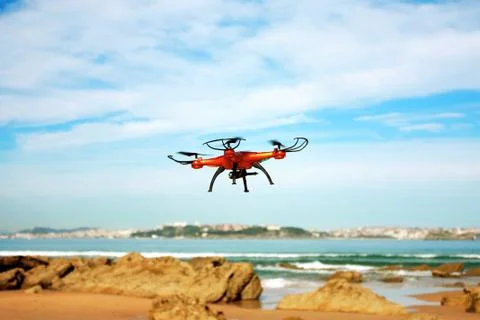 Flying drone with mounted camera on the beach Stock Photos