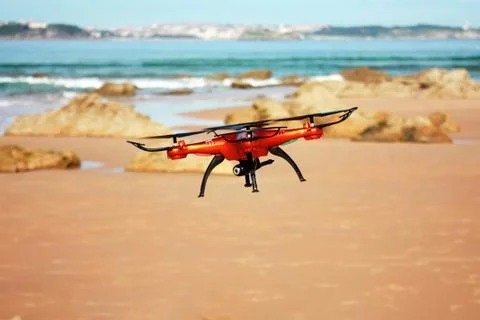 Flying drone with mounted camera on the beach Stock Photos