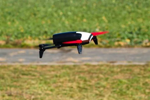 Flying drone with mounted camera in the park Stock Photos