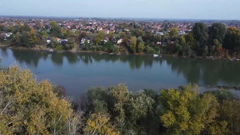 Flying up with a drone next a river revealing the skyline  Video stock 228673236