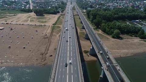 Flying with a drone over the bridge on a summer day across the river Stock Footage 126927230