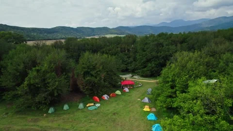 Flying a drone over a camping base with tents in Georgia during daytime, cloudy Stock Footage 252721957