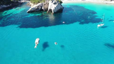 Flying with Drone over Coast and Beach Cala Galdana with Boats on Menorca | 4K Video stock 110214710