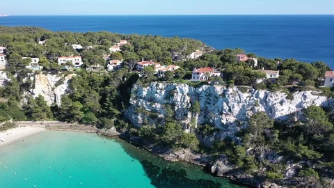 Flying with Drone over Coast and Beach Cala Galdana with Boats on Menorca | 4K Stock Footage 110216712