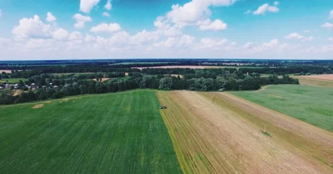 Flying on a Drone Over the Field Where the Tractor Works Stock-Footage 64756051