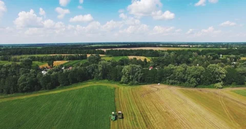 Flying on a Drone Over the Field Where the Tractor Works Stock-Footage 64756063