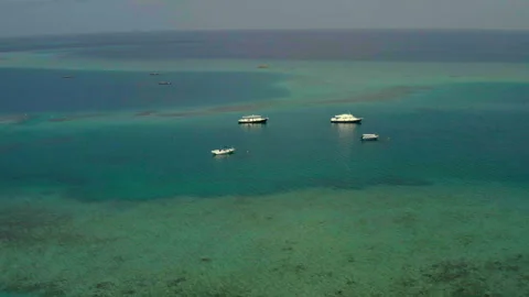 Flying a drone over a group of small boats standing on an island Stock Footage 243428606