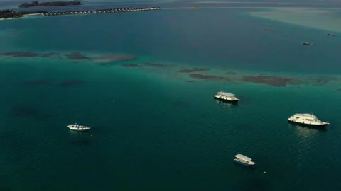 Flying a drone over a group of small boats standing on an island Stock Footage 243428654