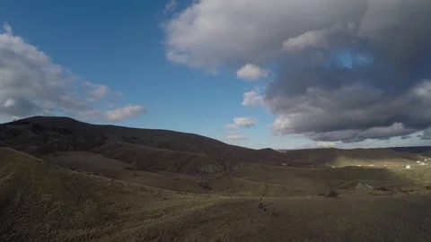 The flying of the drone over the hills beneath the strange clouds Stock Footage 86565128