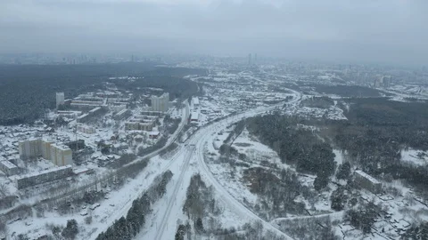 Flying on drone over a long train passing at a suburban station, winter forest Stock Footage 126386586