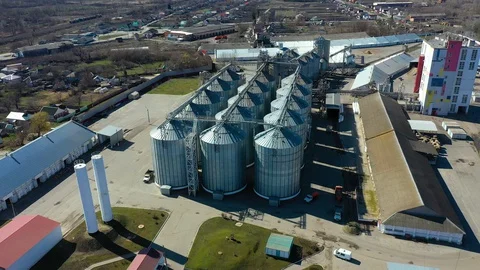 Flying on drone over modern grain storage facilities, agribusiness, farming in Stock Footage 127720386