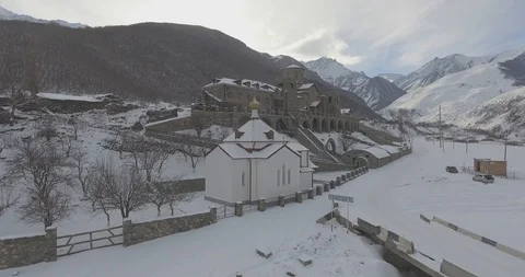 Flying on a drone over a monastery in the mountains in winter Stock Footage 94662321