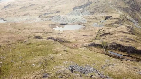 Flying a drone over the mountain and lake. aerial view of road in Wales Stock Footage 295875520