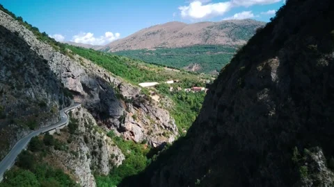 Flying drone over mountains with winding mountain road and forest. Italy Abruzzo Stock Footage 217525358